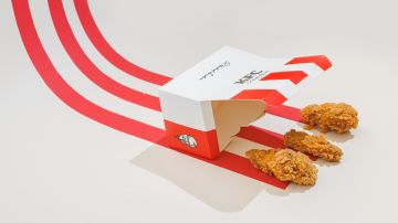 Una caja de cartón de KFC con tres nuggets de pollo que salen, hay unas tiras de color rojo que siguen a la caja en un movimiento curvo.