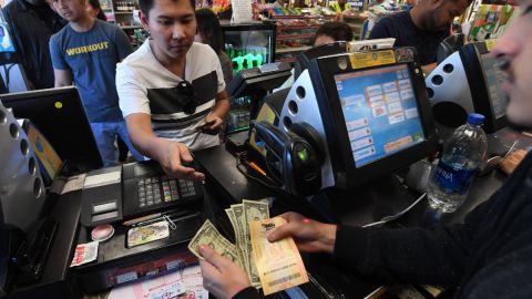 Una persona se encuentra en una caja registradora mientras compra boletos del sorteo Mega Millions.