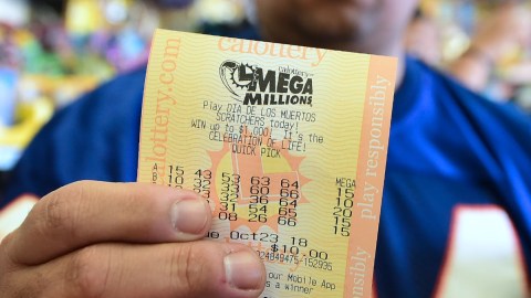 Una persona muestra con sus manos un boleto digital de la lotería Mega Millions.