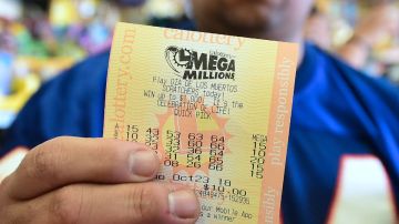 Una persona muestra con sus manos un boleto digital de la lotería Mega Millions.