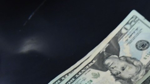 Imagen de varios boletos de Mega Millions y boletos varias denominaciones de billetes de dólar.