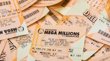 Muchos boletos de lotería están amontonados y destaca uno de la lotería Mega Millions.