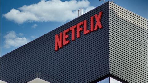 El letrero en rojo de Netflix colocado en el muro de un edificio de color gris.