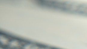 Una casa de plástico verde en miniatura que está colocada sobre un billete de $50 dólares.