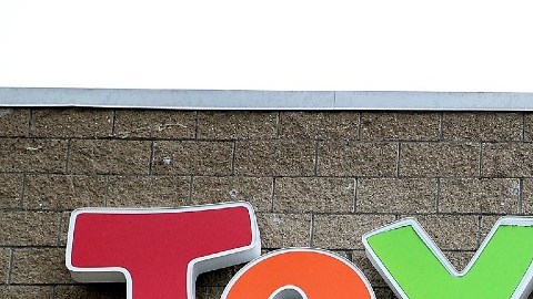 Imagen de una marquesina de la marca de jugueterías Toys'R'us, en una fachada de piedra gris.