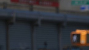 Un trabajador sostiene una señal de tránsito en medio del cierre de una calle por obras.