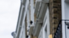 Fachas de varios departamentos y al frente un letrero de venta en color azul y blanco.