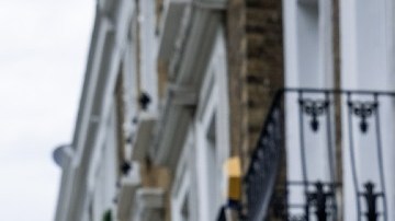 Fachas de varios departamentos y al frente un letrero de venta en color azul y blanco.