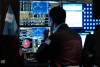 Una persona observa monitores con indicadores financieros y bursátiles en Wall Street.