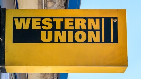 Un letrero de color amarillo de la marca Western Union colocado en una calle.