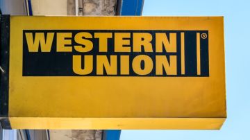 Un letrero de color amarillo de la marca Western Union colocado en una calle.