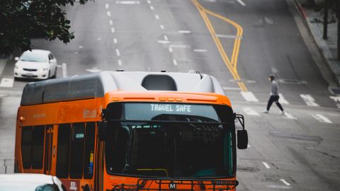 A man crosses a street as a city bus passes in the other direction, in downtown Los Angeles, California, on April 30, 2020. - A recent surge in the number of novel coronavirus cases and deaths linked to COVID-19 has brought California to two milestones, as the state is poised to surpass 50,000 infections and 2,000 deaths. (Photo by Robyn Beck / AFP) (Photo by ROBYN BECK/AFP via Getty Images)