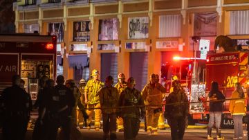 A firefighter walks near firetrucks after a fire in a single-story commercial building sparked an explosion in the Toy District of downtown Los Angeles on May 16, 2020. - At least 11 firefighters were injured in downtown Los Angeles when a fire in a commercial building sparked a major explosion and spread to nearby structures, fire officials said. Some 230 responders battled the blaze as it spread to other buildings in the area before it was extinguished around two hours after it began. (Photo by Apu GOMES / AFP) (Photo by APU GOMES/AFP via Getty Images)