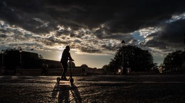TOPSHOT - A man wearing a face mask rides an electric scooter at sunset in Paris, on August 31, 2020. (Photo by Martin BUREAU / AFP) (Photo by MARTIN BUREAU/AFP via Getty Images)