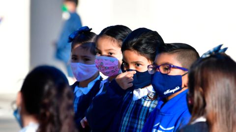 A students adjusts her facemask at St. Joseph Catholic School in La Puente, California on November 16, 2020, where pre-kindergarten to Second Grade students in need of special services returned to the classroom today for in-person instruction. - The campus is the second Catholic school in Los Angeles County to receive a waiver approval to reopen as the coronavirus pandemic rages on. The US surpassed 11 million coronavirus cases Sunday, adding one million new cases in less than a week, according to a tally by Johns Hopkins University. (Photo by Frederic J. BROWN / AFP) (Photo by FREDERIC J. BROWN/AFP via Getty Images)