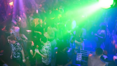 People dance and drink before a reimposed indoor mask mandate at the Trunks bar Saturday night before midnight on July 17, 2021 in West Hollywood, California. - Wearing a face mask at indoor public establishments will once again be mandatory in Los Angeles County starting at 11:59 pm July 17, 2021 for both vaccinated and unvaccinated people due to a steady increase in Covid-19 infections and hospitalizations, health authorities said. (Photo by Patrick T. FALLON / AFP) (Photo by PATRICK T. FALLON/AFP via Getty Images)