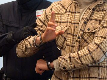 A judical officer brings handcuffed defendant Mohamed R. into the courtroom in Dresden, Germany, on March 15, 2022, for the continuation of the trial over a jewellery heist on the Green Vault (Gruenes Gewoelbe) museum in Dresden's Royal Palace in November 2019. - Six members of a notorious criminal gang, aged 22 to 28, are on trial in Germany over the spectacular heist in which 18th-century jewels were snatched from the state museum in Dresden. They are accused of gang robbery and arson after the brazen night raid on The Green Vault museum on November 25, 2019. (Photo by MATTHIAS RIETSCHEL / POOL / AFP) (Photo by MATTHIAS RIETSCHEL/POOL/AFP via Getty Images)