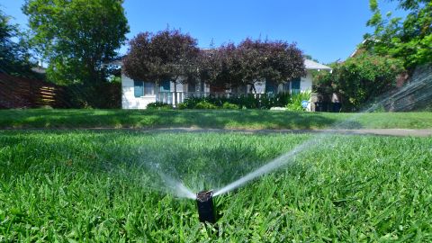 An automated sprinkler waters grass in front of homes in Alhambra, California on April 27, 2022, a day after Southern California delared a water shortage emergency with unprecedented new restrictions on outdoor watering for millions of people living in Los Angeles, San Bernardino and Ventura counties. - Southern California's Metropolitan water district will allow for outdoor watering tp just one day per week effective June 1st. (Photo by Frederic J. BROWN / AFP) (Photo by FREDERIC J. BROWN/AFP via Getty Images)