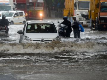 VIDEO: Ebrio es arrastrado por una coladera en calle inundada y lo salvan de milagro