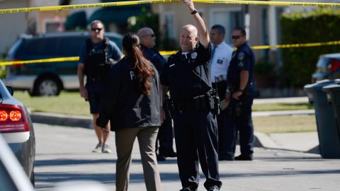 DOWNEY, CA - OCTOBER 24: Police stand outside two story house after a shooting and at a fire protection business nearby killing two people and injuring three others on October 24, 2012 in Downey, California. Police are still searching for the gunman who stole a car and escaped. (Photo by Kevork Djansezian/Getty Images)