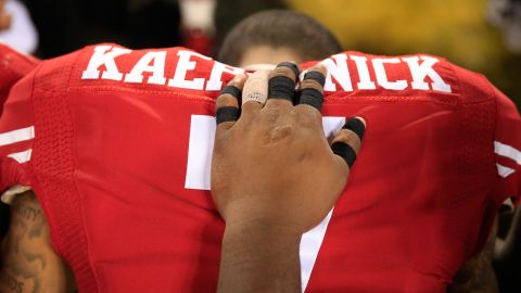 El mariscal de campo Colin Kaepernick #7 de los San Francisco 49ers ora con los miembros de los Baltimore Ravens luego de su juego de pretemporada de la NFL en el M&T Bank Stadium el 7 de agosto de 2014 en Baltimore, Maryland.