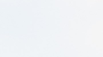 Una persona muestra una big mac con la mano frente a un logotipo de McDonald's.