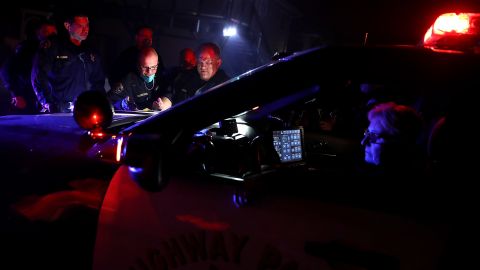 SONOMA, CA - OCTOBER 11: California Highway Patrol officers look over a map of a neighborhood as they go door-to-door to ask residents to voluntarily evacuate as a wildfire approaches on October 11, 2017 in Sonoma, California. Twenty one people have died in wildfires that have burned tens of thousands of acres and destroyed over 3,000 homes and businesses in several Northen California counties. (Photo by Justin Sullivan/Getty Images)