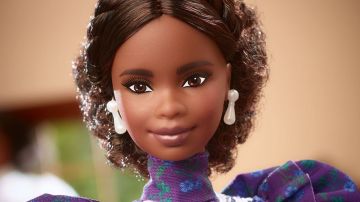 El rostro de una muñeca Barbie con cabello chino, piel negra y aretes.