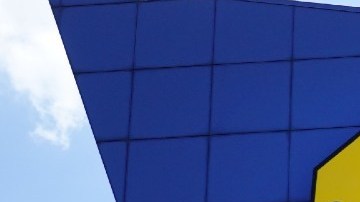 Fachada de una tienda Best Buy con un letrero amarillo fijado al muro.