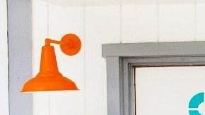 Imagen de la entrada de un motel con una silla de color azul y una bicicleta en el frente.