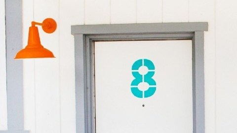 Imagen de la entrada de un motel con una silla de color azul y una bicicleta en el frente.