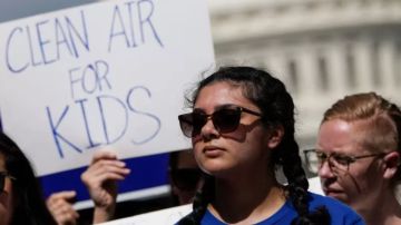 "Aire limpio para los niños", se lee en la pancarta de una manifestante a favor de la ley aprobada este viernes