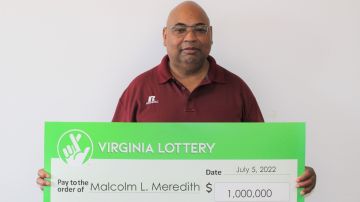 Imagen de Malcolm Meredith, uno de los ganadores del Mega Millions, con un gran cheque en las manos.