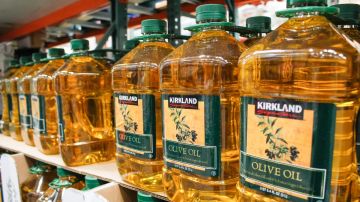 Envases de aceite de oliva de la marca Kirkland colocados en un estante en una tienda Costco.
