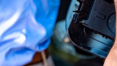 Una personas carga gasolina en su vehículo de color negro.