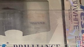 Estantería de productos asegurados con cajas y etiquetas de precios.