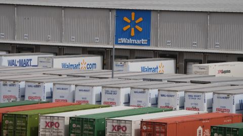 Imagen de un logotipo de la cadena Walmart, en medio de un parque de camiones de carga y cajas de tráiler.
