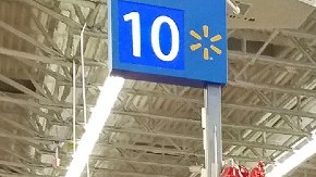 Cajas de pago en una sucursal de Walmart en las que se ven personas pagando y cobradores.