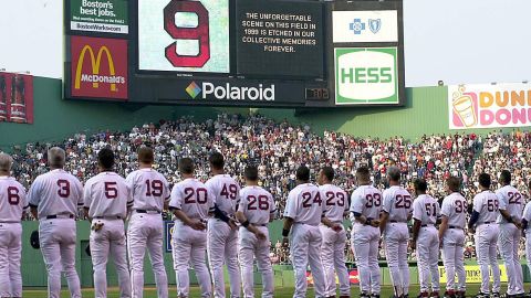 Los miembros de los Medias Rojas de Boston rinden homenaje a Ted Williams bajo un gran número 9, el número uniforme de Williams, durante una ceremonia antes de su juego con los Tigres de Detroit el 5 de julio de 2002 en Fenway Park en Boston, Massachusetts.