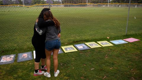 Edith Gonzalez and Kimberly Fuentes embrace as they look at signs made by family and friends of people who died after being poisoned by pills containing fentanyl, including their friend Adrian De Jesus, before a protest outside of the Snap, Inc. headquarters, makers of the Snapchat social media application, on June 4, 2021 in Santa Monica, California. - The coalition of family members and groups including Alexander Neville Foundation, APALD, and Drug Induced Homicide, advocate for greater parental controls on the Snapchat app, countermeasures to block the sale of illegal drugs, assistance with law enforcement investigations into drug dealers, and to raise awareness about counterfeit drugs and pills that contain unregulated and deadly amounts of the synthetic opioid fentanyl. (Photo by Patrick T. FALLON / AFP) (Photo by PATRICK T. FALLON/AFP via Getty Images)