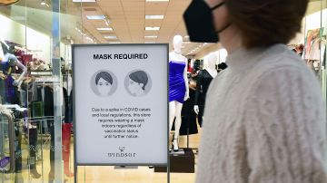 A shopping mall boutique sign requiring facemask for entry is pictured at a shopping mall in Santa Anita, California on December 20, 2021. (Photo by Frederic J. BROWN / AFP) (Photo by FREDERIC J. BROWN/AFP via Getty Images)