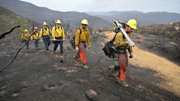 Firefighters walk on a scorched landscape from the Fairview Fire inside the San Bernardino National Forest near Hemet, California on September 9, 2022. - The wildfire burning outside Los Angeles has doubled in size in less than 24 hours, firefighters said on September 8 as they endured yet another day of blistering heat in the western US. Thousands of people have been told to evacuate in the face of the growing fire, which has now spread to 19,000 acres (7,700 hectares). (Photo by Frederic J. BROWN / AFP) (Photo by FREDERIC J. BROWN/AFP via Getty Images)