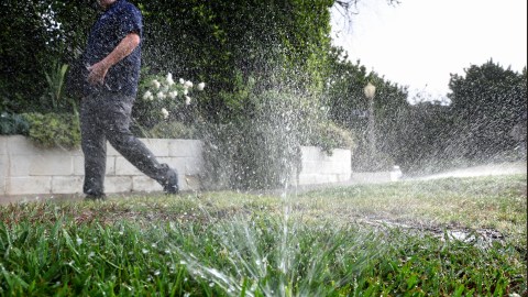 LOS ANGELES, CALIFORNIA - JULY 27: Los Angeles Department of Water and Power (LADWP) water conservation specialist Damon Ayala walks while inspecting a sprinkler system, which is operating in violation of the water conservation ordinance, on July 27, 2022 in Los Angeles, California. Amid California’s ongoing drought, Ayala and other public servants with the Water Conservation Response Unit patrol the city for lawn watering violations and respond to water waste reports from members of the community. Following increased lawn watering restrictions due to the drought, Angelenos recorded the lowest all-time water use for any June recorded in the City of Los Angeles. (Photo by Mario Tama/Getty Images)