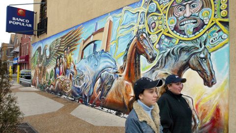 Dos mujeres pasan ante un mural en el vecindario hispano "La Villita" en Chicago.