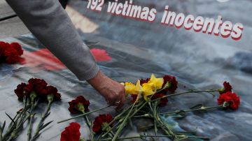 Una mujer coloca flores para las víctimas de los atentados con bombas en los trenes de Madrid durante una reunión conmemorativa fuera de la estación de tren de Atocha en el décimo aniversario el 11 de marzo de 2014 en Madrid, España.
