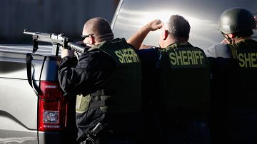 SAN BERNARDINO, CA - DECEMBER 02: San Bernadino Sheriff officers point weapons into a neighborhood as they pursue suspects of the shooting at the Inland Regional Center on December 2, 2015 in San Bernardino, California. Police continue to search for suspects in the shooting that left at least 14 people dead and another 17 injured. (Photo by Sean M. Haffey/Getty Images)