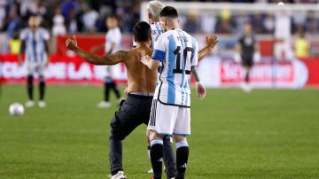 Messi le firma la espalda a un fanático que saltó al terreno de juego en el encuentro contra Jamaica.