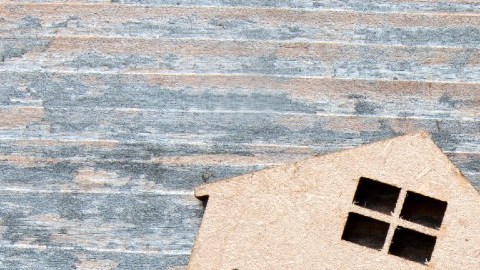 Imagen de una casa de cartón con una etiqueta de alquiler.