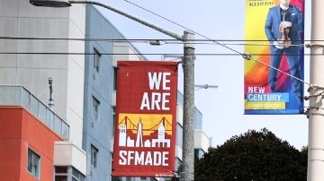 Imagen de un apartamento con las escaleras de emergencia visibles, un letrero con letras azules y rojas de alquiler y un auto blanco.