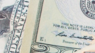 Imagen de unas llaves sobre varios billetes de dólares americanos.